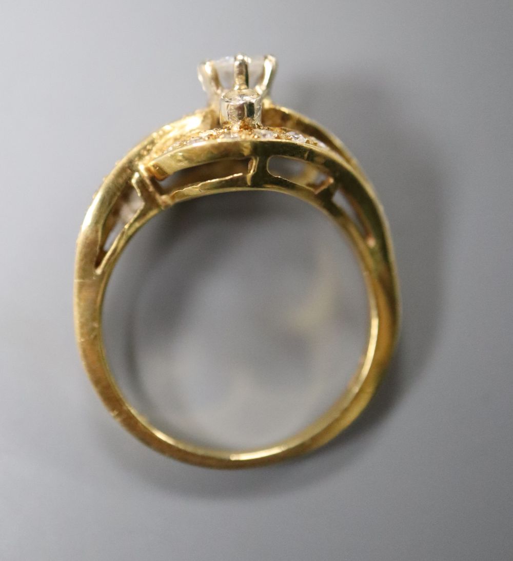 An 18ct yellow gold and diamond ring of scroll design, size O, gross 6 grams.